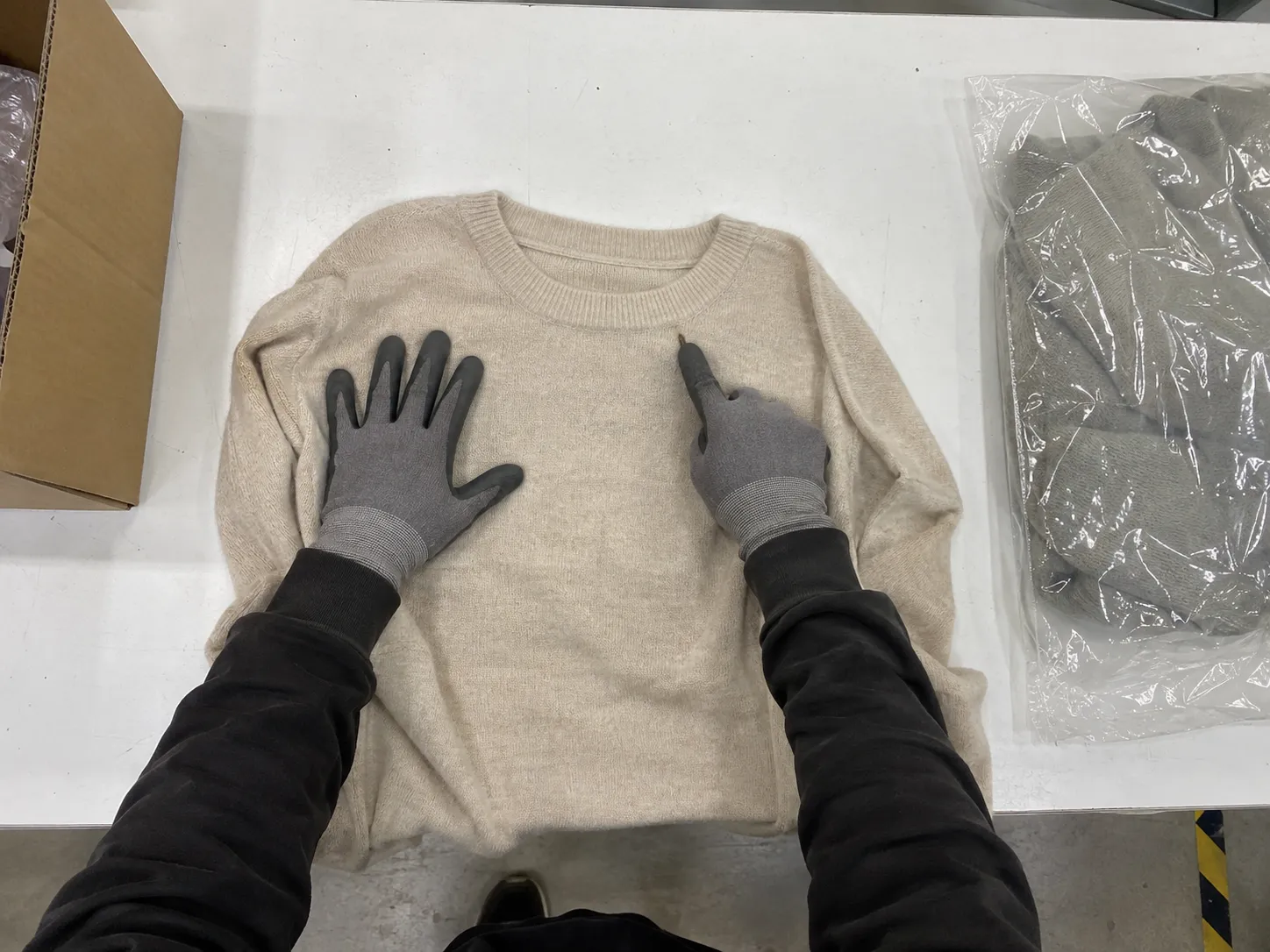 Overhead view of a garment being inspected on the bench